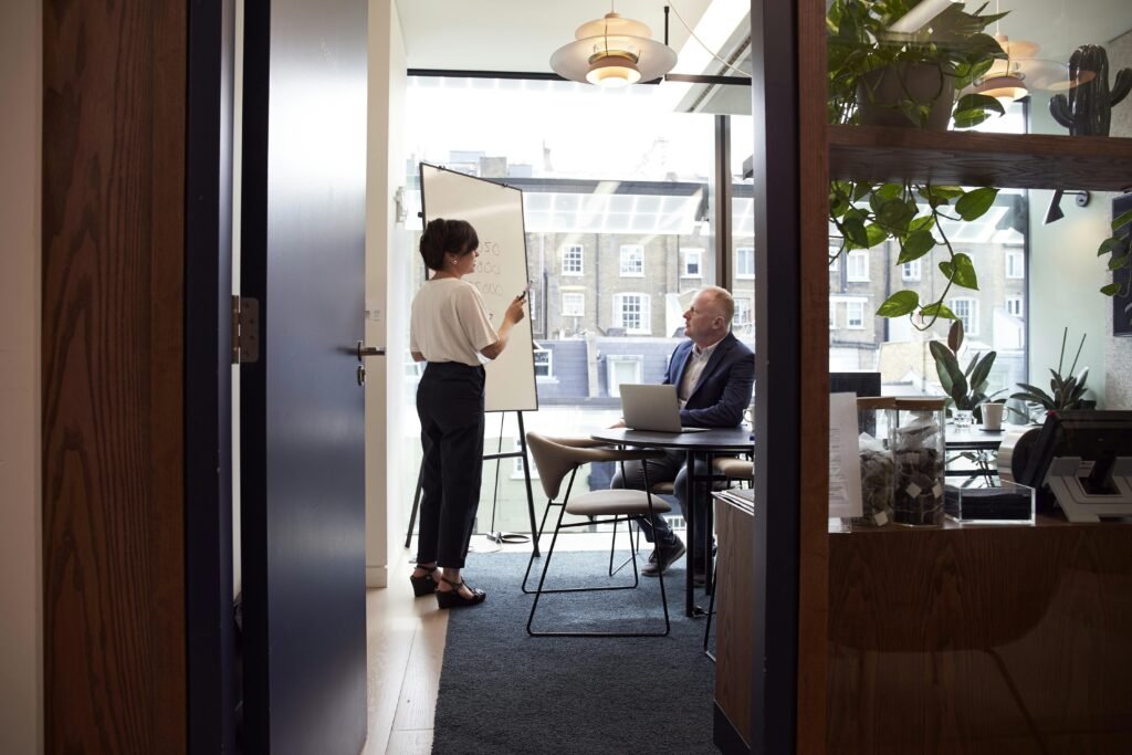 pexels-thecoachspace-2977547 A one-on-one mentoring session between a consultant and a young professional, set in a modern office or a cozy meeting room.